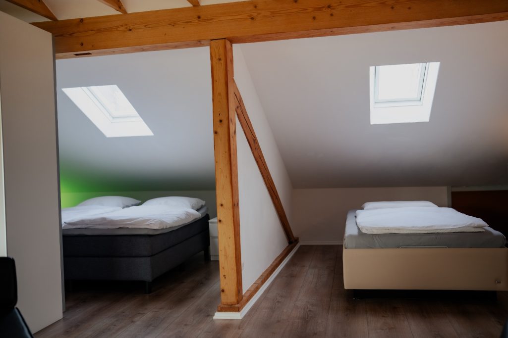 Gemütliche Dachgeschosszimmer mit zwei Betten und Dachfenstern.